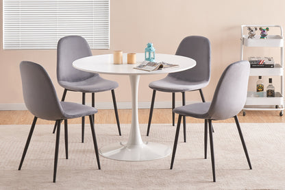 White round dining table with grey velvet chairs